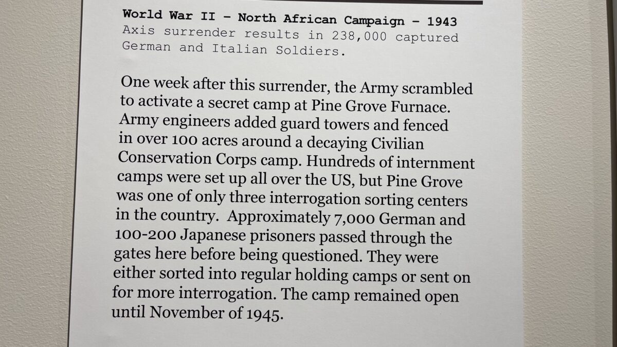 In this image, hundreds of German and Japanese prisoners of war are being held at the Pine Grove POW Camp in the United States during World War II. Full Text: The Pine Grove POW Camp World War II - North African Campaign - 1943 Axis surrender results in 238,000 captured German and Italian Soldiers. One week after this surrender, the Army scrambled to activate a secret camp at Pine Grove Furnace. Army engineers added guard towers and fenced in over 100 acres around a decaying Civilian Conservation Corps camp. Hundreds of internment camps were set up all over the US, but Pine Grove was one of only three interrogation sorting centers in the country. Approximately 7,000 German and 100-200 Japanese prisoners passed through the gates here before being questioned. They were either sorted into regular holding camps or sent on for more interrogation. The camp remained open until November of 1945.