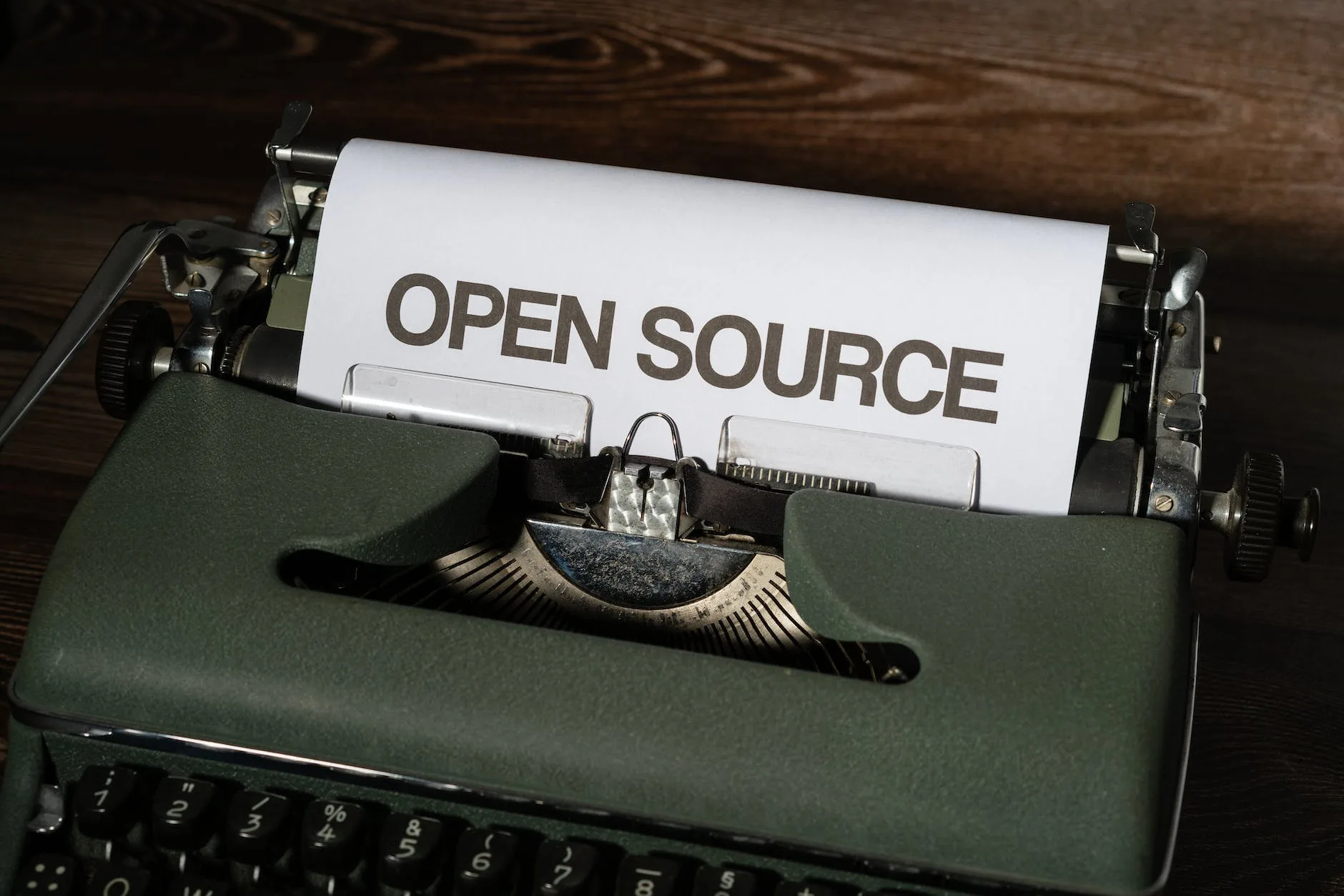 A typewriter with a sheet of paper that reads open source.