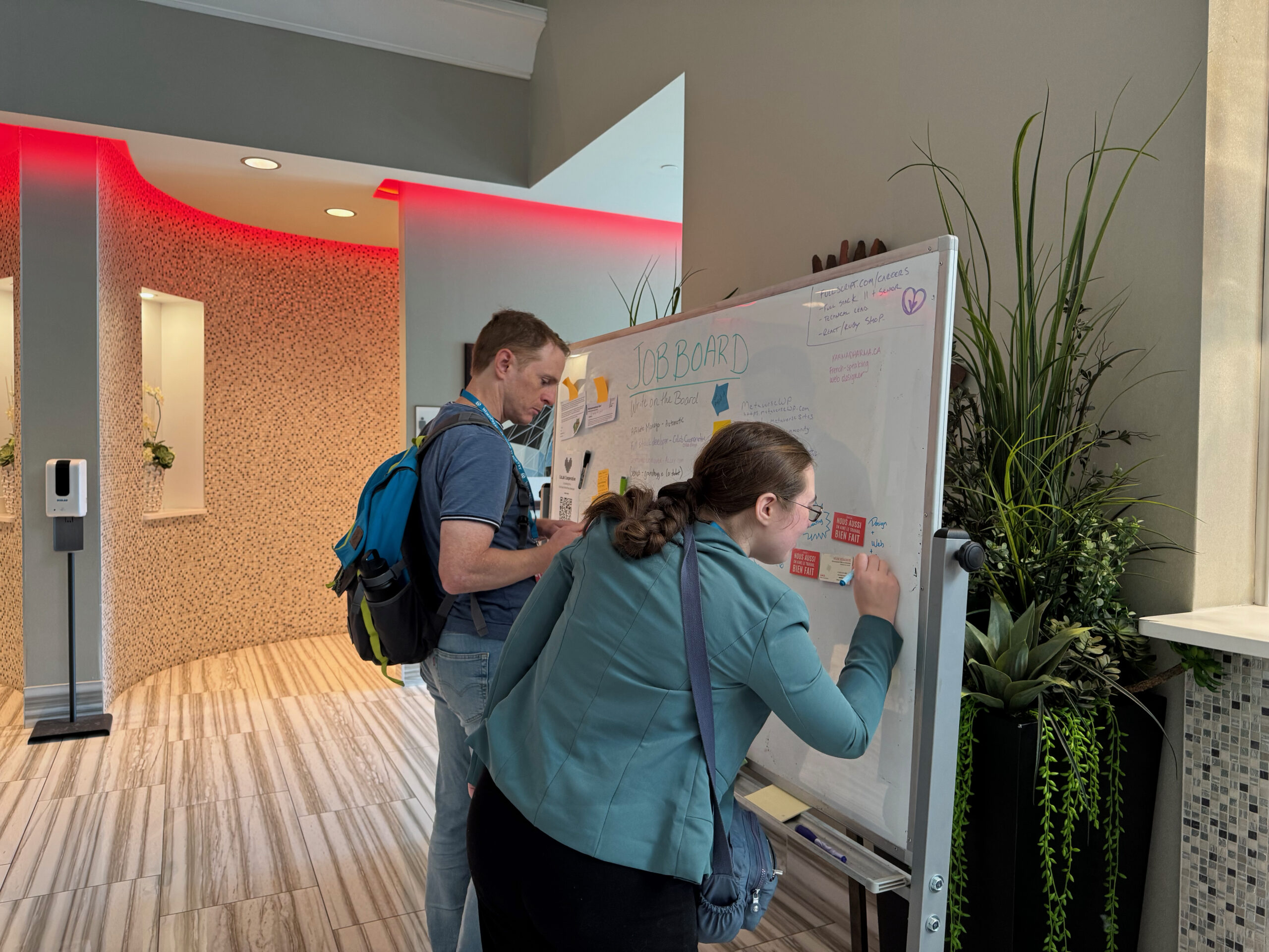 Attendees writing on the jobs board