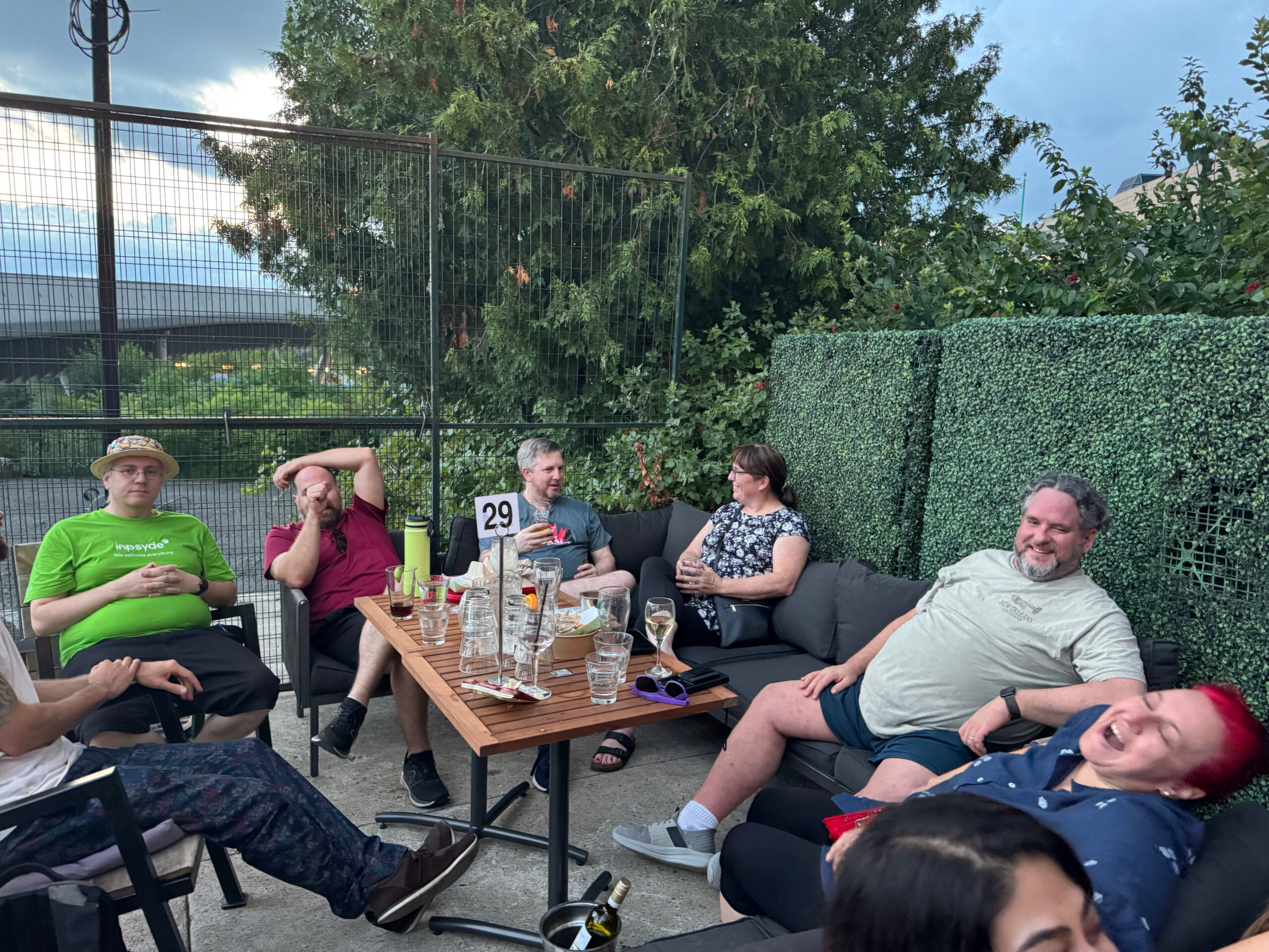 Sitting in lawn furniture around table are: Robert Windisch, Stephane, Kiera Hwoe, Matt Graham, and Shanta Nathwani.  